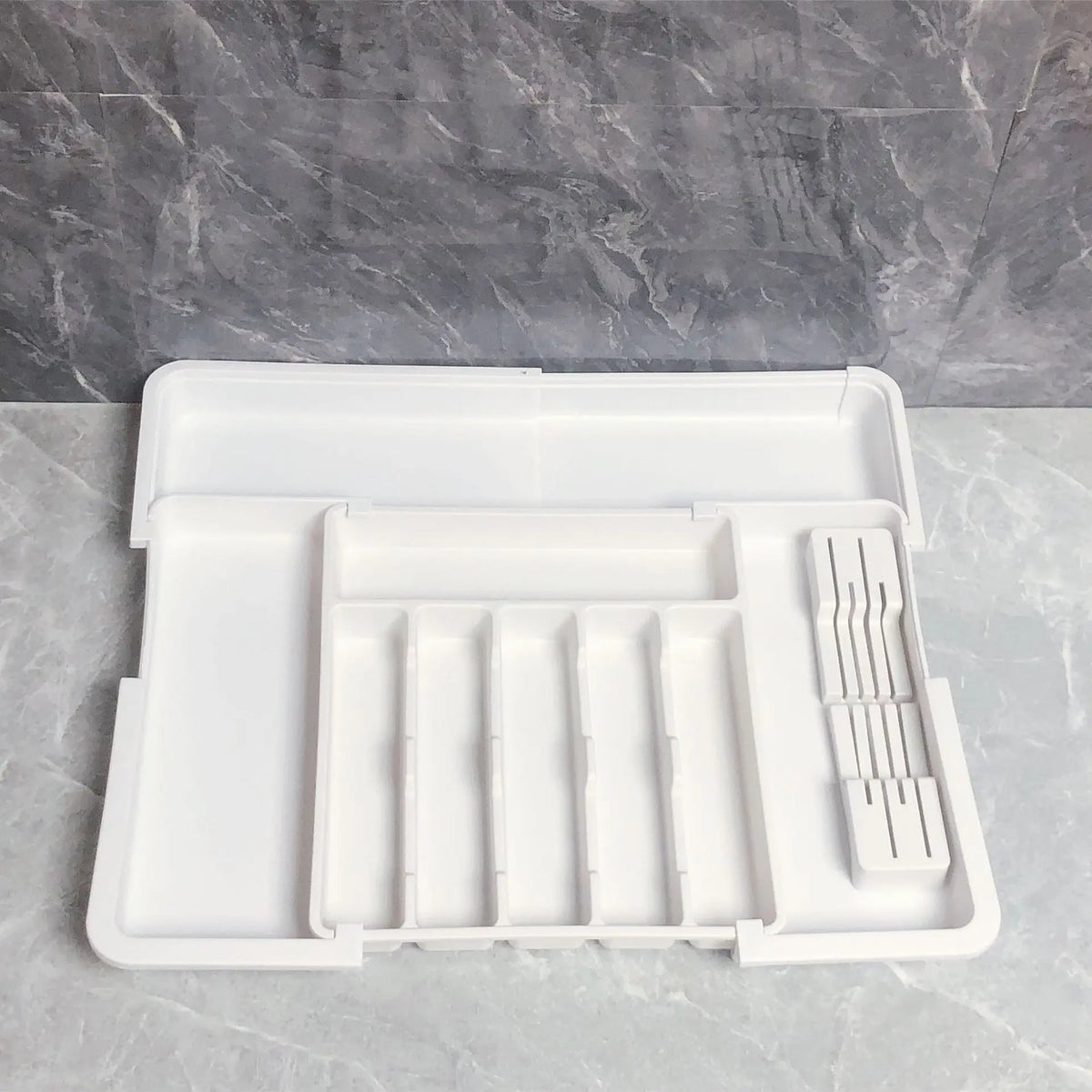 Justerbar og sammenleggbar bestikkorganisator i plast